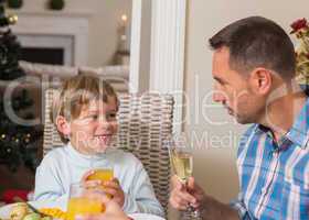 Portrait of father and son holding glass