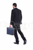 Businessman walking while holding briefcase