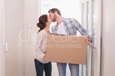 Cute couple carrying cardboard box