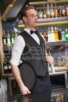 Serious waiter holding tray and towel