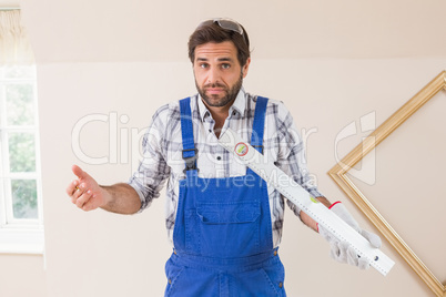 Confused construction worker holding spirit level