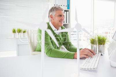 Casual businessman working with model wind turbines