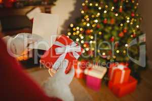 Santa claus holding paper and gift