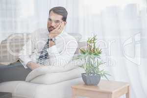 Businessman sitting on his couch seen through glass