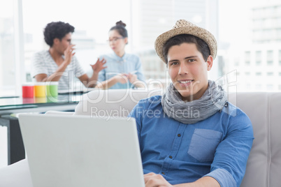 Young creative man using laptop on couch