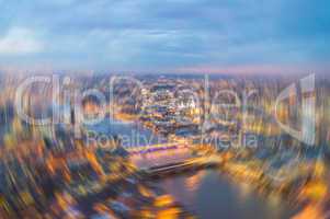 London at night. Blurred aerial city view with Thames river and