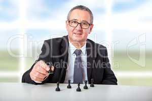 Man thinks strategically with chess pieces on the desk