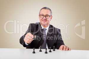 Man thinks strategically with chess pieces on the desk