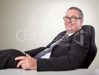 Happy man sitting at desk and leans back