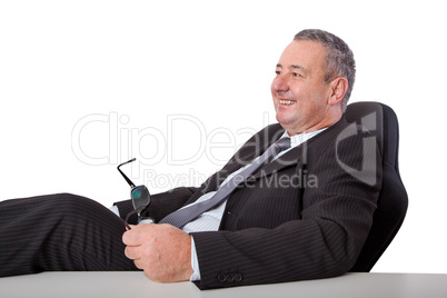 Happy man sitting at desk and leans back