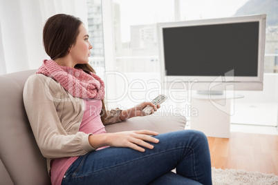 Pretty brunette watching tv on couch
