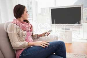 Pretty brunette watching tv on couch