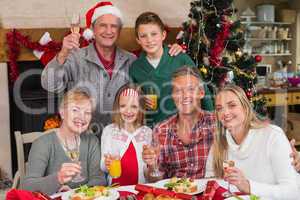 Family toasting with white wine in a christmas dinner