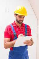 Construction worker taking notes on clipboard