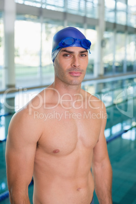 Shirtless fit swimmer by pool at leisure center