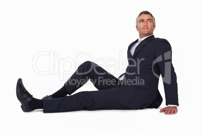 Smiling businessman sitting on the floor