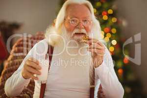 Smiling santa claus eating a cookie