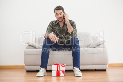 Confused man looking at gifts on floor