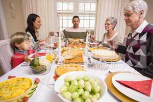 Extended family saying grace before christmas dinner