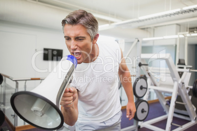 Angry personal trainer shouting through megaphone