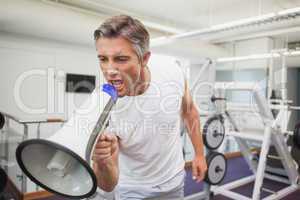 Angry personal trainer shouting through megaphone