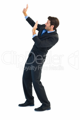 Focused businessman pushing with hands