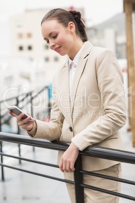 Young businesswoman sending a text