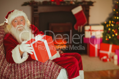 Cheerful santa claus offering a gift