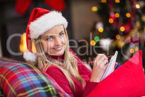 Blonde sitting on the couch writing her christmas list