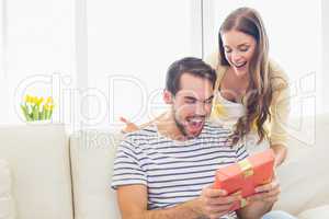 Pretty woman surprising her boyfriend with gift