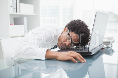 Businessman with glasses sleeping on laptop