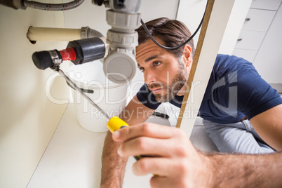 Plumber fixing under the sink