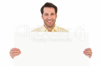 Attractive man smiling and holding poster