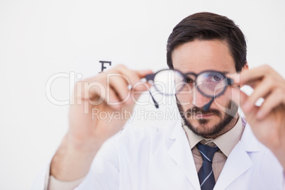 Doctor wearing lab coat looking through eyeglasses