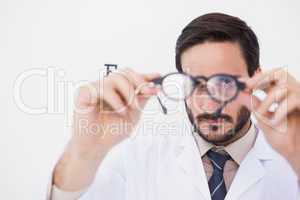 Doctor wearing lab coat looking through eyeglasses