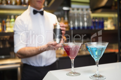 Attractive bar man making a cocktail