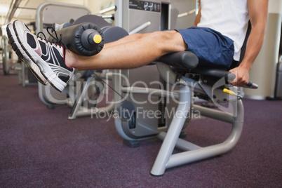 Fit man using weights machine for legs