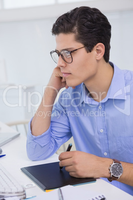 Casual graphic designer working at his desk