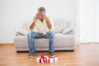 Man talking on phone looking at gifts