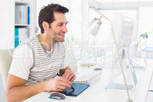 Casual man working at desk with computer and digitizer