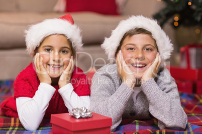 Smiling brother and sister lying on the cover