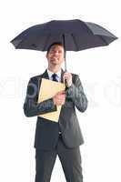 Businessman sheltering under umbrella holding file
