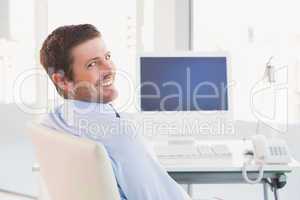 Smiling businessman sitting at his desk