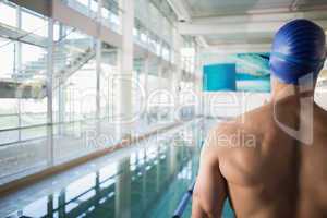 Rear view of shirtless swimmer by pool at leisure center