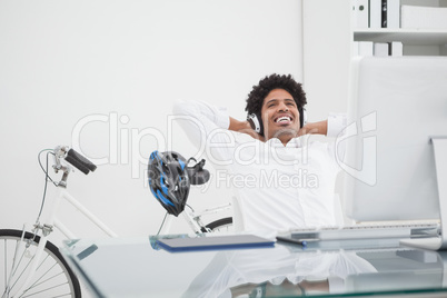 Relaxed designer with headphones leaning back in his chair