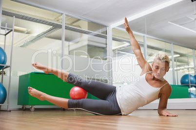 Full length of woman doing fitness exercise in gym