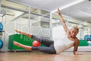 Full length of woman doing fitness exercise in gym