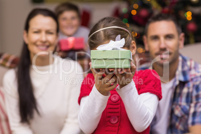 Daughter showing a gift with her family behind