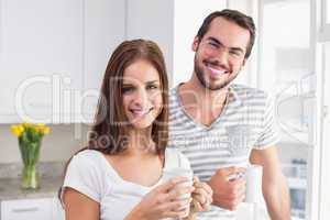 Young couple smiling at the camera having coffee