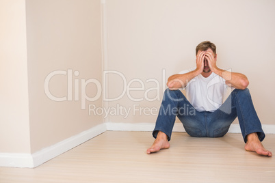 Depressed man sitting on floor